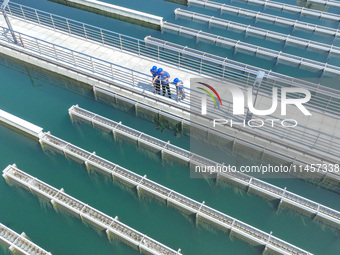 Workers are inspecting various water supply equipment at Qinghong Water Plant in Qianyuan town, Deqing County, Huzhou city, Zhejiang provinc...