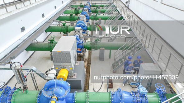 Workers are inspecting various water supply equipment at Qinghong Water Plant in Qianyuan town, Deqing County, Huzhou city, Zhejiang provinc...