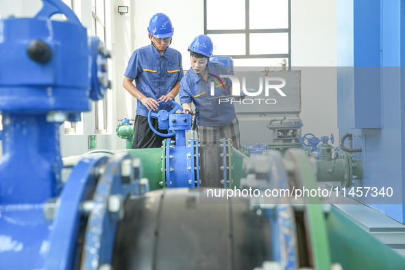 Workers are inspecting various water supply equipment at Qinghong Water Plant in Qianyuan town, Deqing County, Huzhou city, Zhejiang provinc...