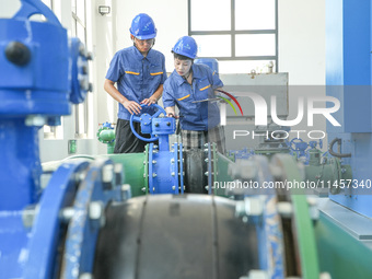 Workers are inspecting various water supply equipment at Qinghong Water Plant in Qianyuan town, Deqing County, Huzhou city, Zhejiang provinc...