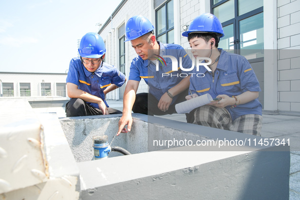 Workers are inspecting various water supply equipment at Qinghong Water Plant in Qianyuan town, Deqing County, Huzhou city, Zhejiang provinc...