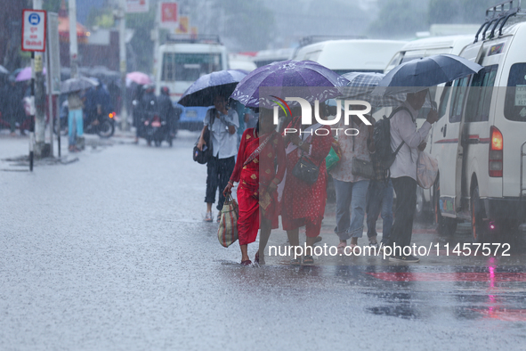 People are wading through flooded roads in Kathmandu, Nepal, on August 6, 2024. Nepal's Meteorological Forecasting Division (MFD) under the...