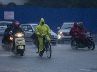 A cyclist is wearing a raincoat and pedaling through the flooded streets of Kathmandu, Nepal, on August 6, 2024. Nepal's Meteorological Fore...