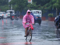 A cyclist is wearing a raincoat and pedaling through the flooded streets of Kathmandu, Nepal, on August 6, 2024. Nepal's Meteorological Fore...