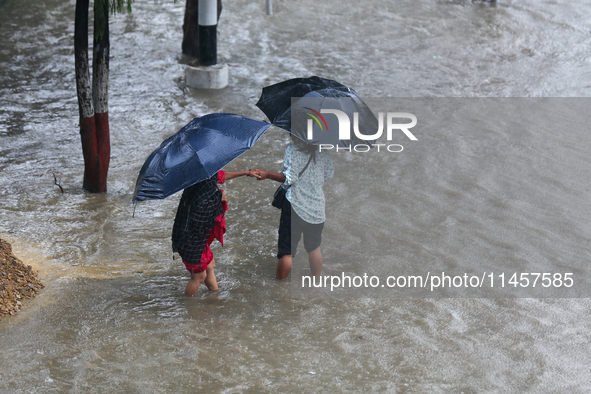 People are wading through flooded roads in Kathmandu, Nepal, on August 6, 2024. Nepal's Meteorological Forecasting Division (MFD) under the...