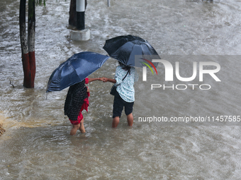 People are wading through flooded roads in Kathmandu, Nepal, on August 6, 2024. Nepal's Meteorological Forecasting Division (MFD) under the...