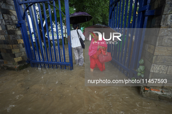 People are wading through flooded roads in Kathmandu, Nepal, on August 6, 2024. Nepal's Meteorological Forecasting Division (MFD) under the...