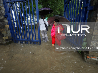 People are wading through flooded roads in Kathmandu, Nepal, on August 6, 2024. Nepal's Meteorological Forecasting Division (MFD) under the...