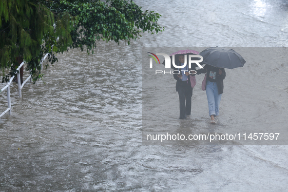 People are wading through flooded roads in Kathmandu, Nepal, on August 6, 2024. Nepal's Meteorological Forecasting Division (MFD) under the...