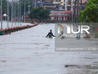 Children are wading through a flooded area on the embankments of Bagmati River in Teku, Kathmandu, Nepal, on August 6, 2024. Nepal's Meteoro...