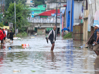 People are wading through flood water carrying their belongings and other items of necessity in Kathmandu, Nepal, on August 6, 2024. Nepal's...