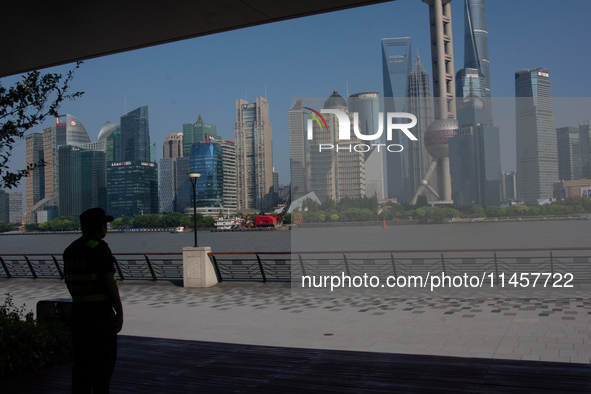 A security worker is protecting under the shadow in North Bund, Shanghai, China, on August 6, 2024. 