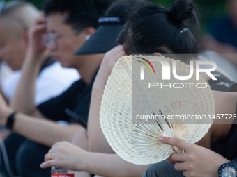 People are resting at the Bund in Shanghai, China, on August 6, 2024. (