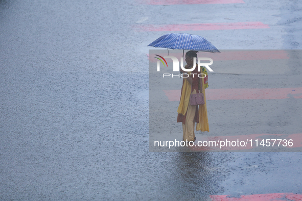 A Nepali woman is wading through flooded roads in Kathmandu, Nepal, on August 6, 2024. Nepal's Meteorological Forecasting Division (MFD) und...