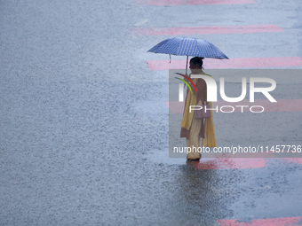 A Nepali woman is wading through flooded roads in Kathmandu, Nepal, on August 6, 2024. Nepal's Meteorological Forecasting Division (MFD) und...