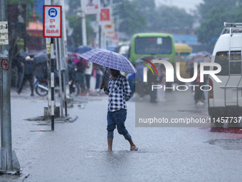 A man is wading through flooded roads in Kathmandu, Nepal, on August 6, 2024. Nepal's Meteorological Forecasting Division (MFD) under the De...