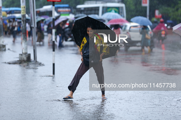 A woman is wading through flooded roads in Kathmandu, Nepal, on August 6, 2024. Nepal's Meteorological Forecasting Division (MFD) under the...