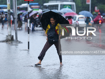 A woman is wading through flooded roads in Kathmandu, Nepal, on August 6, 2024. Nepal's Meteorological Forecasting Division (MFD) under the...