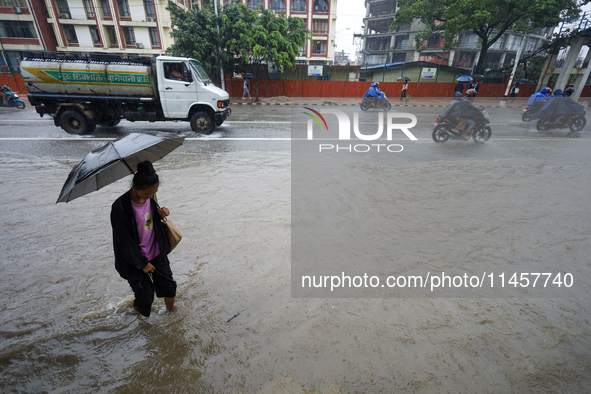 People are wading through flooded roads in Kathmandu, Nepal, on August 6, 2024. Nepal's Meteorological Forecasting Division (MFD) under the...