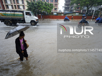 People are wading through flooded roads in Kathmandu, Nepal, on August 6, 2024. Nepal's Meteorological Forecasting Division (MFD) under the...