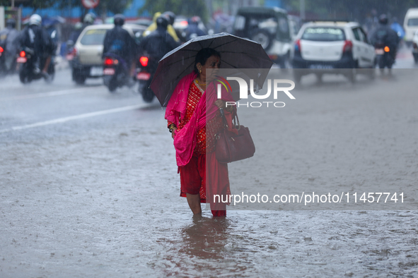 A Nepali woman is wading through flooded roads in Kathmandu, Nepal, on August 6, 2024. Nepal's Meteorological Forecasting Division (MFD) und...