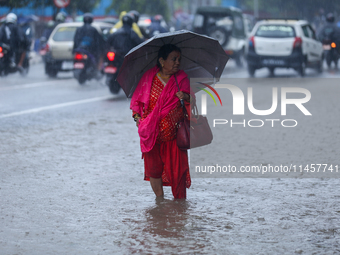 A Nepali woman is wading through flooded roads in Kathmandu, Nepal, on August 6, 2024. Nepal's Meteorological Forecasting Division (MFD) und...