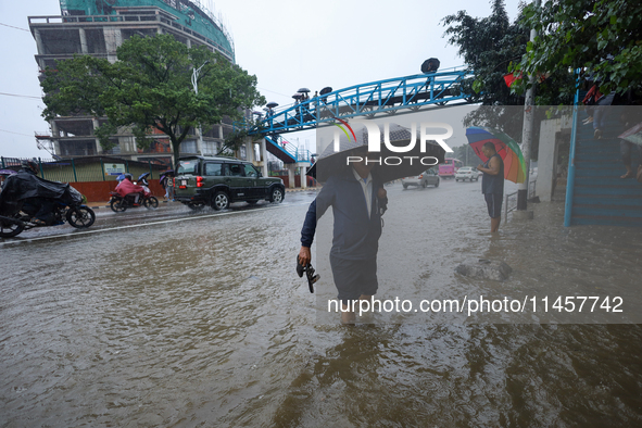 People are wading through flooded roads in Kathmandu, Nepal, on August 6, 2024. Nepal's Meteorological Forecasting Division (MFD) under the...