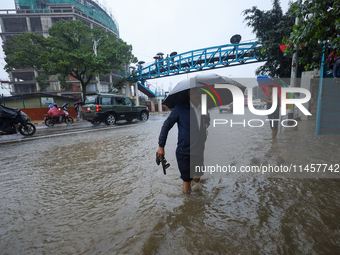 People are wading through flooded roads in Kathmandu, Nepal, on August 6, 2024. Nepal's Meteorological Forecasting Division (MFD) under the...