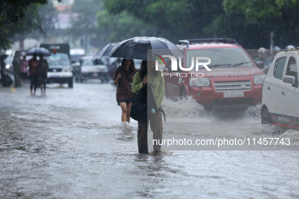 People are wading through flooded roads in Kathmandu, Nepal, on August 6, 2024. Nepal's Meteorological Forecasting Division (MFD) under the...