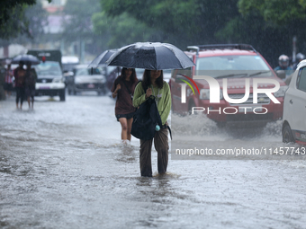 People are wading through flooded roads in Kathmandu, Nepal, on August 6, 2024. Nepal's Meteorological Forecasting Division (MFD) under the...