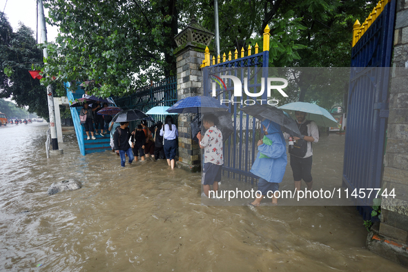 People are wading through flooded roads in Kathmandu, Nepal, on August 6, 2024. Nepal's Meteorological Forecasting Division (MFD) under the...