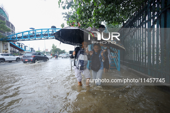 People are wading through flooded roads in Kathmandu, Nepal, on August 6, 2024. Nepal's Meteorological Forecasting Division (MFD) under the...