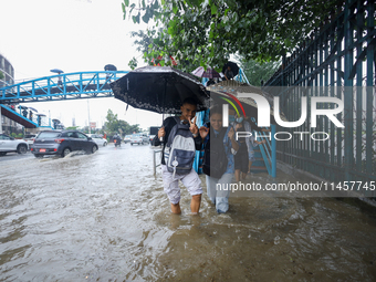 People are wading through flooded roads in Kathmandu, Nepal, on August 6, 2024. Nepal's Meteorological Forecasting Division (MFD) under the...