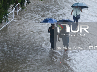 People are wading through flooded roads in Kathmandu, Nepal, on August 6, 2024. Nepal's Meteorological Forecasting Division (MFD) under the...