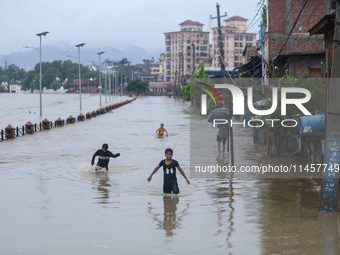 Children are wading through a flooded area on the embankments of Bagmati River in Teku, Kathmandu, Nepal, on August 6, 2024. Nepal's Meteoro...