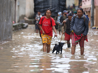 People are wading through flood water carrying their belongings and other items of necessity in Kathmandu, Nepal, on August 6, 2024. Nepal's...