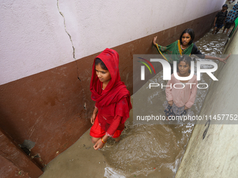 People are wading through flood water carrying their belongings and other items of necessity in Kathmandu, Nepal, on August 6, 2024. Nepal's...