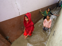 People are wading through flood water carrying their belongings and other items of necessity in Kathmandu, Nepal, on August 6, 2024. Nepal's...