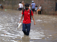 A boy is wading through flooded water on the embankments of Bagmati River in Balkhu of Kathmandu, Nepal, on August 6, 2024. Nepal's Meteorol...