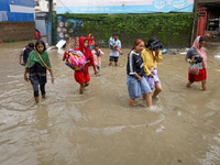 People are wading through flood water carrying their belongings and other items of necessity in Kathmandu, Nepal, on August 6, 2024. Nepal's...