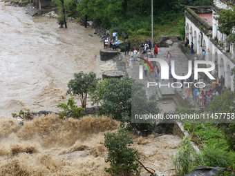 People are watching the flooded Bagmati River at Chovar in Kathmandu, Nepal, on August 6, 2024. Nepal's Meteorological Forecasting Division...