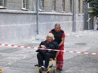 A paramedic is pushing an injured woman in an evacuation chair to an ambulance after the Russian rocket attack in Kharkiv, Ukraine, on Augus...