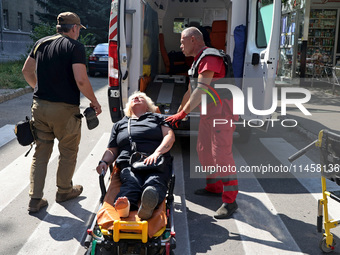 A paramedic is staying by a woman at an ambulance after the Russian rocket attack in Kharkiv, Ukraine, on August 6, 2024. Russians are strik...