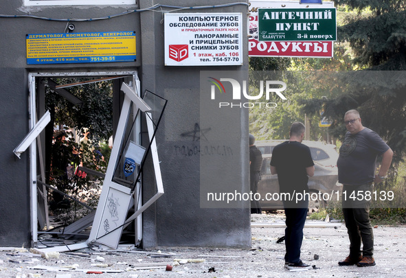 Men are standing by a damaged building after the Russian rocket attack in Kharkiv, Ukraine, on August 6, 2024. On Tuesday morning, August 6,...