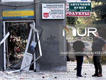 Men are standing by a damaged building after the Russian rocket attack in Kharkiv, Ukraine, on August 6, 2024. On Tuesday morning, August 6,...