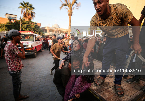 Palestinian medics are transporting an injured person following Israeli bombardment on Deir el-Balah into the Al-Aqsa Martyrs hospital in th...