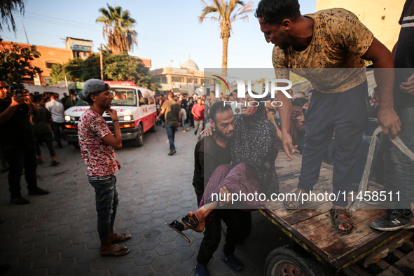 Palestinian medics are transporting an injured person following Israeli bombardment on Deir el-Balah into the Al-Aqsa Martyrs hospital in th...