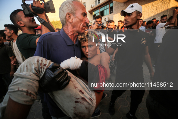 Palestinian medics are transporting an injured person following Israeli bombardment on Deir el-Balah into the Al-Aqsa Martyrs hospital in th...