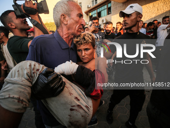 Palestinian medics are transporting an injured person following Israeli bombardment on Deir el-Balah into the Al-Aqsa Martyrs hospital in th...