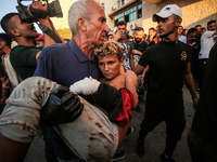 Palestinian medics are transporting an injured person following Israeli bombardment on Deir el-Balah into the Al-Aqsa Martyrs hospital in th...